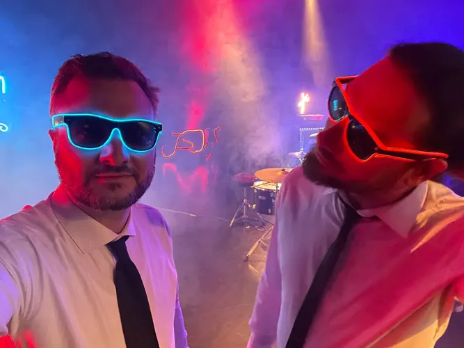 Dvojica sa neonskim naočarima i kravatama